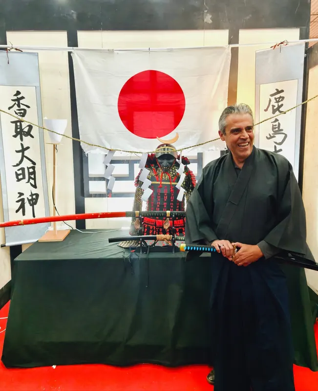 Il maestro in kimono con la katana, fra calligrafie giapponesi e un'armatura da samurai