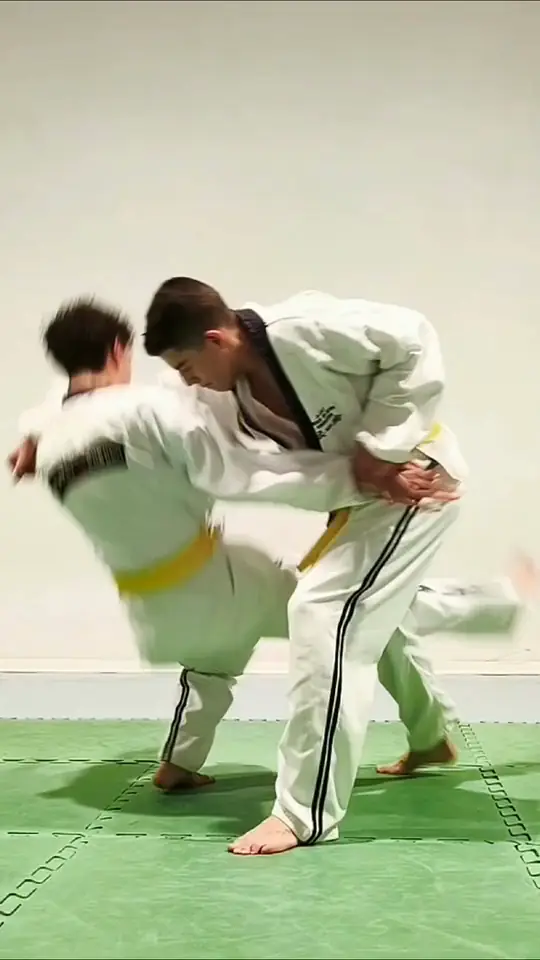 Video di un allenamento: proiezioni fra allievi in divisa bianca sul tatami verde